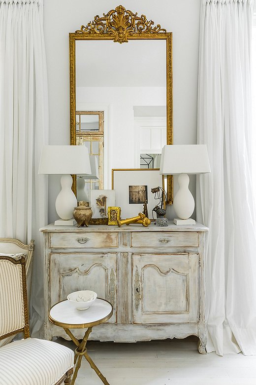 Whites, creams, and golds are the only colors, and the striped upholstery the only pattern, but this space is engaging nonetheless, thanks to the layers of textures and tones. Photo courtesy of Julie O’Neill.
